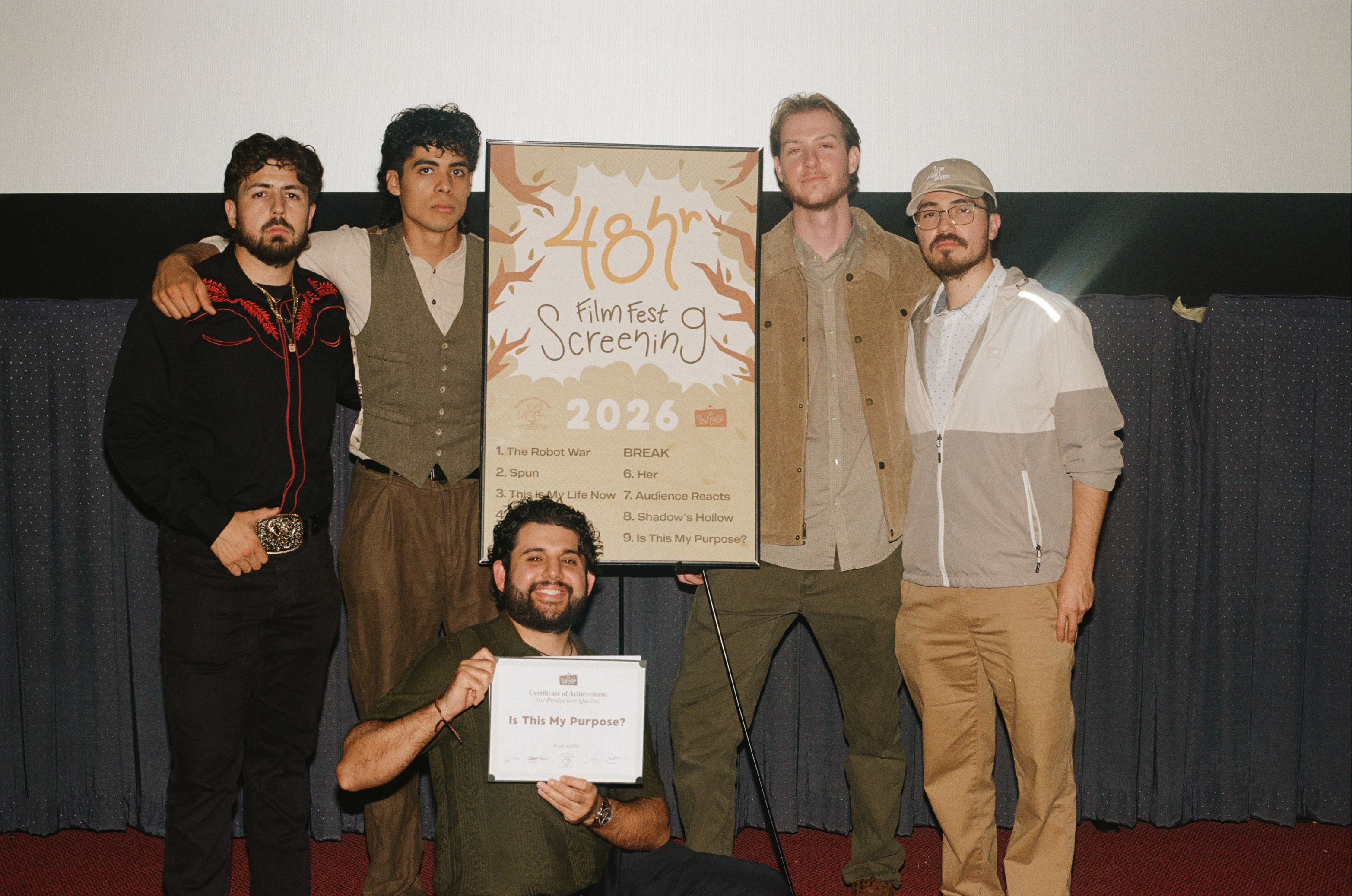 Team with their certificate at the screening sign